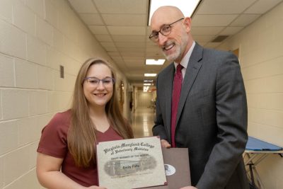 Dean Dan Givens presents the March 2024 Staff Member of the Month award to Emily Falls.