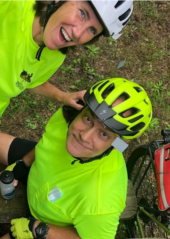 Two people taking a selfie in bright green cycling gear.